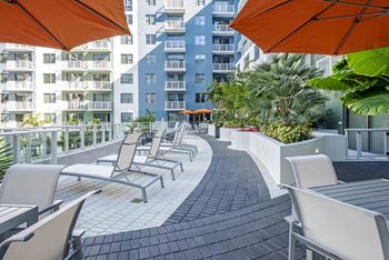 A patio with chairs and umbrellas overlooking a city.